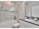 Well-lit bathroom with a shower-tub combo, granite countertop, a white vanity, and a decorative mirror at 2117 Lake Waters Pl, Lutz, FL 33558