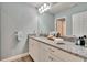 Bathroom features granite countertops, white cabinets, and updated lighting at 2117 Lake Waters Pl, Lutz, FL 33558