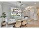 Elegant dining room with a decorative light fixture, sleek white walls, and modern tile floors at 2117 Lake Waters Pl, Lutz, FL 33558