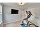 Light filled room features hardwood floors, a modern light fixture, and space for exercise equipment at 2117 Lake Waters Pl, Lutz, FL 33558