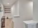 Hallway with wooden floors and shelving, leading into a room at 2117 Lake Waters Pl, Lutz, FL 33558