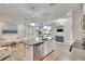 Bright kitchen with a center island, stainless steel appliances, and white cabinets opens to the living and dining area at 2117 Lake Waters Pl, Lutz, FL 33558