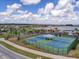 Well-maintained community tennis courts with shelters and seating, adjacent to a scenic lake at 2117 Lake Waters Pl, Lutz, FL 33558