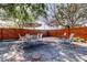 Fenced backyard featuring dining table and chairs under mature trees at 2131 Cedar Dr, Dunedin, FL 34698
