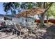 Spacious outdoor dining set under a large umbrella, within a fenced backyard at 2131 Cedar Dr, Dunedin, FL 34698