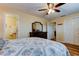 Bright bedroom featuring wood-look floors, ceiling fan, and ensuite bathroom access at 2131 Cedar Dr, Dunedin, FL 34698