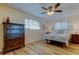 Bedroom features wood-look floors, ceiling fan, and dresser at 2131 Cedar Dr, Dunedin, FL 34698
