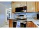 Close up of stainless steel oven, microwave, granite countertops, and wood cabinets at 2131 Cedar Dr, Dunedin, FL 34698