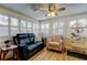 Inviting sunroom with ample natural light, ceiling fan, and cozy furniture at 2131 Cedar Dr, Dunedin, FL 34698
