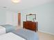 Bright bedroom features neutral walls, twin beds with blue accents, and a classic wood dresser with mirror at 2171 E Vina Del Mar Blvd, St Pete Beach, FL 33706