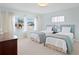 Bright bedroom features neutral walls, twin beds with blue accents, and natural light from an exterior window at 2171 E Vina Del Mar Blvd, St Pete Beach, FL 33706