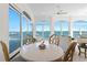 Bright dining area with white table, ceiling fan and large glass doors with a beautiful water view at 2171 E Vina Del Mar Blvd, St Pete Beach, FL 33706