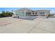 Wide view of home exterior, large yard, partial fence, and light colored hardscape at 2171 E Vina Del Mar Blvd, St Pete Beach, FL 33706