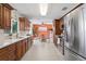 Well-equipped kitchen with stainless steel appliances, warm wood cabinetry, and an adjacent dining area at 2171 E Vina Del Mar Blvd, St Pete Beach, FL 33706