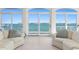 Bright living room with white tile floor and large glass doors revealing beautiful water view at 2171 E Vina Del Mar Blvd, St Pete Beach, FL 33706