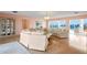 Open-concept living room with panoramic water views, stylish furniture, and a display cabinet at 2171 E Vina Del Mar Blvd, St Pete Beach, FL 33706