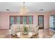 Bright living room with a decorative chandelier and ornate glass doors leading to an outdoor area at 2171 E Vina Del Mar Blvd, St Pete Beach, FL 33706
