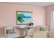 Cozy sitting area featuring a framed painting of a beach scene, plush chairs, and a glass-topped table at 2171 E Vina Del Mar Blvd, St Pete Beach, FL 33706