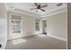 Sun-filled bedroom with neutral paint, carpet flooring, two windows, and an open closet with built-in storage at 2320 Coffee Pot Ne Blvd, St Petersburg, FL 33704