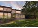 Spacious backyard featuring a screened-in patio, lush lawn, and mature trees for privacy at 25 Woods Landing Trl, Oldsmar, FL 34677
