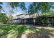 Home's backyard with a screened-in patio, surrounded by lush greenery and trees at 25 Woods Landing Trl, Oldsmar, FL 34677