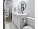 Well-lit bathroom featuring a white vanity, black hardware, and round mirror at 25 Woods Landing Trl, Oldsmar, FL 34677