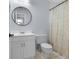 Classic bathroom with white vanity, round mirror, and patterned shower curtain at 25 Woods Landing Trl, Oldsmar, FL 34677