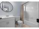 Bathroom with white cabinets and tub, featuring a round mirror and updated fixtures at 25 Woods Landing Trl, Oldsmar, FL 34677