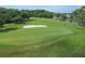 Well-manicured golf course with a sand trap and a serene lake in the backdrop at 25 Woods Landing Trl, Oldsmar, FL 34677