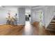 Open-concept living space showcasing hardwood floors, a staircase, and barstool seating leading to the kitchen at 25 Woods Landing Trl, Oldsmar, FL 34677