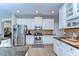 Bright kitchen featuring stainless steel appliances, granite countertops, and white cabinetry at 2515 Cross More St, Valrico, FL 33594