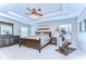 Spacious main bedroom featuring a tray ceiling, ceiling fan, and modern exercise equipment at 2515 Cross More St, Valrico, FL 33594
