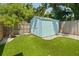 Turfed backyard with storage shed, palm tree, and wood privacy fence at 2751 36Th N Ave, St Petersburg, FL 33713