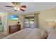 Bedroom with access to patio, ceiling fan, chest, and bedside table lamps. and access to Primary bathroom at 3106 Whispering S Dr, Largo, FL 33771