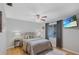 Bedroom with a wrought iron bed frame, neutral bedding, a ceiling fan, and a mounted TV for relaxation at 3106 Whispering S Dr, Largo, FL 33771