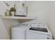 Laundry room featuring side-by-side washer and dryer, and hot water heater on elevated shelf above machines at 3106 Whispering S Dr, Largo, FL 33771
