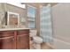 Bathroom with tiled floor, dark wood vanity and marble countertop and a toilet next to the tub at 3408 W Bay Ave, Tampa, FL 33611