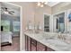 Bathroom featuring double sink vanity with marble countertop and a view into an adjacent bedroom at 3408 W Bay Ave, Tampa, FL 33611