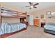 Bedroom with bunk beds, ceiling fan, dresser, nightstand and two twin beds with striped bedding at 3408 W Bay Ave, Tampa, FL 33611
