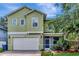 Charming two-story home features a two car garage, well-manicured lawn, and inviting front porch, providing a welcoming curb appeal at 3408 W Bay Ave, Tampa, FL 33611