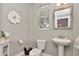 Charming powder room with pedestal sink, decorative mirror, and tiled floors at 3408 W Bay Ave, Tampa, FL 33611
