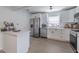 Modern kitchen featuring white cabinets, stainless steel appliances, and light wood-look flooring at 428 Flamingo Dr, Apollo Beach, FL 33572