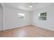 Bright bedroom features hardwood floors, a ceiling fan, and natural light from two windows at 4550 53Rd N Ave, St Petersburg, FL 33714
