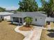 Exterior view featuring a well-maintained front yard with landscaping, sidewalk, and a screened-in porch at 4550 53Rd N Ave, St Petersburg, FL 33714