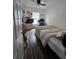 This quaint bedroom includes wood-look floors, a twin bed, and desk near the window for optimal light at 4601 N 38Th St, Tampa, FL 33610