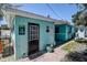 The backyard featuring a shed with a Tiki Cottage sign and a seating area under a clear blue sky at 512 79Th Ave, St Pete Beach, FL 33706