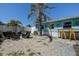 Backyard with decorative stone, a lounge area, dining area, and lush tropical landscaping at 512 79Th Ave, St Pete Beach, FL 33706