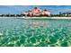 Beautiful beach scene with clear water and a historic pink hotel in the background at 512 79Th Ave, St Pete Beach, FL 33706