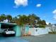 Charming home exterior featuring a white fence, blue siding, and a car in the driveway at 512 79Th Ave, St Pete Beach, FL 33706