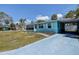 Charming turquoise home with lush landscaping, and an attached carport, creating a inviting curb appeal at 512 79Th Ave, St Pete Beach, FL 33706